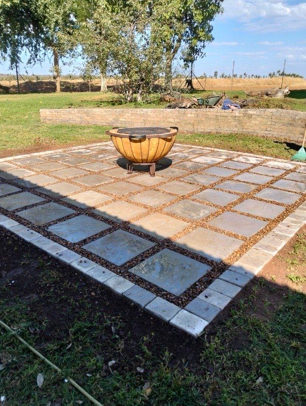 Curved paver walkway winding past cycads and trees